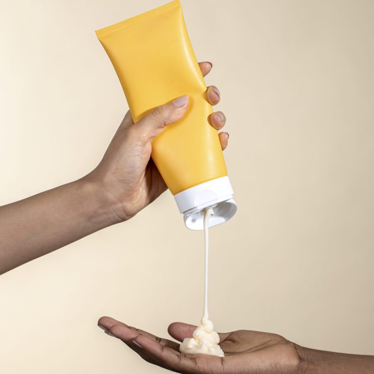 Woman squeezing cream from an unlabeled yellow tube